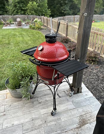 Le Kamado Joe Classic Joe Grill au coin d'une terrasse