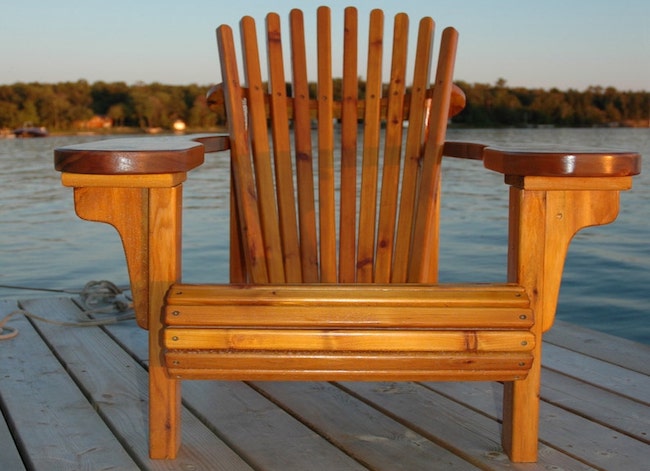 Chaise Adirondack à larges accoudoirs sur une terrasse au bord du lac