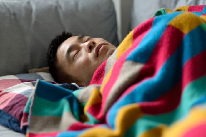 Homme dormant sur un canapé