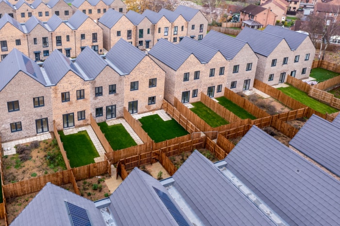 vue aérienne d'un quartier résidentiel avec des panneaux solaires sur les toits et des pelouses vertes