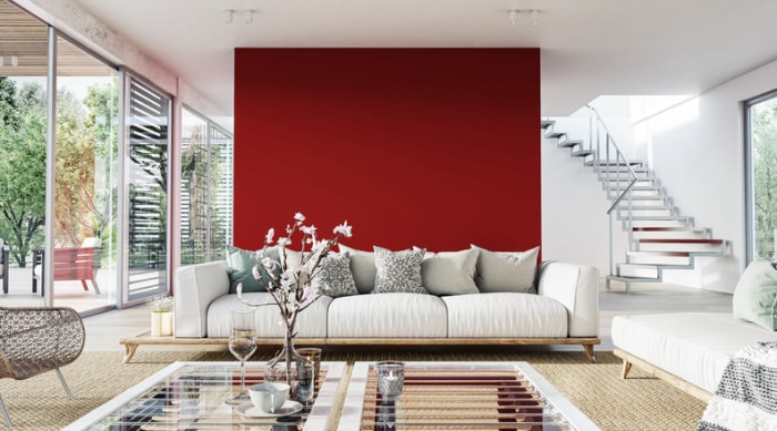 un-mur-d'accent-rouge-lumineux-est-le-fond-d'un-salon-lumineux-décoré-de-blanc-et-de-tan