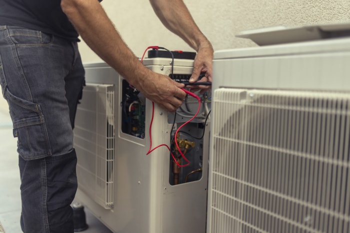 Un électricien installe une pompe à chaleur pour économiser l'énergie.