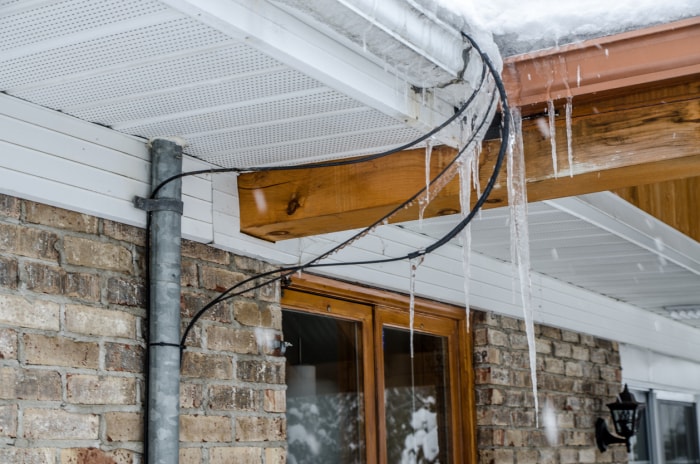 Barrages de glace sur le toit d'une maison lors d'une chaude journée d'hiver