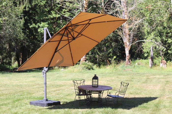 La meilleure option de parasol en porte-à-faux installé au-dessus d'une table de patio dans une cour ensoleillée