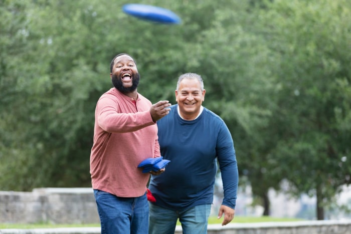 Deux hommes s'amusent en jouant à un jeu de cornhole.