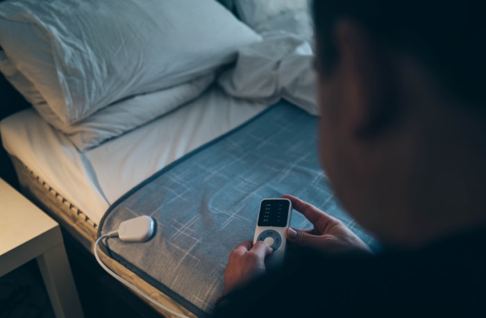 vue aérienne d'un homme testant la température d'une couverture électrique