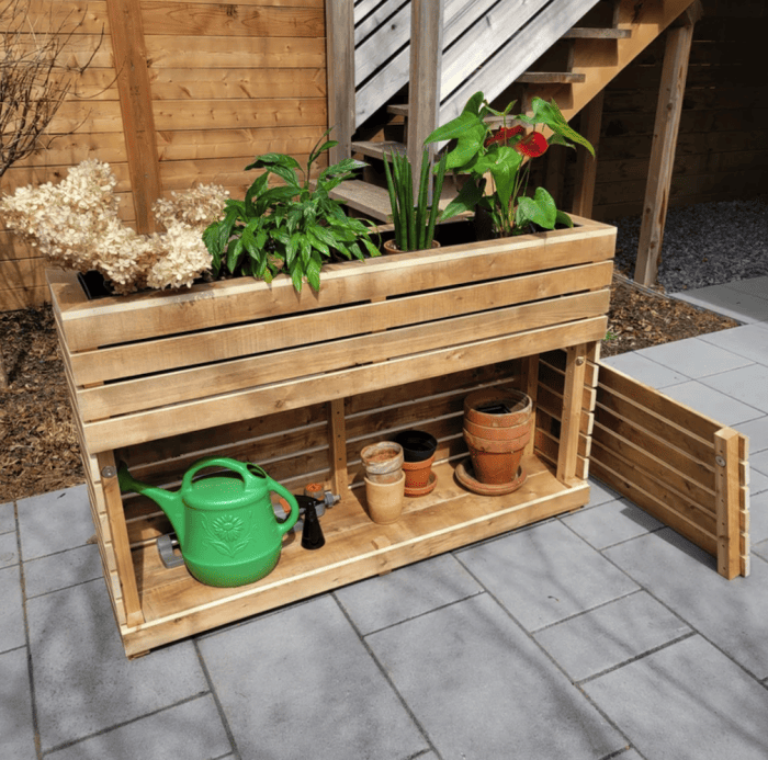 jardinière rectangulaire haute avec armoire apparente contenant un arrosoir et des pots de plantation