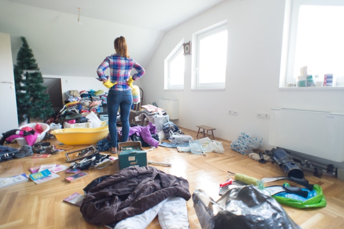 Jeune femme au foyer se préparant à nettoyer le désordre à la maison.