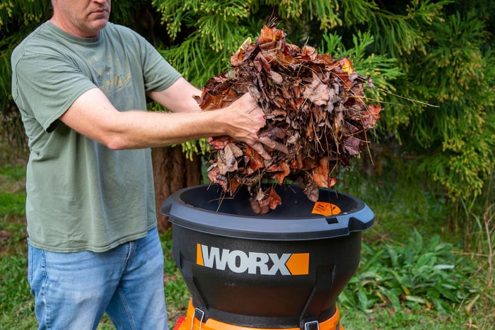 Un homme place des feuilles dans le broyeur de feuilles Worx