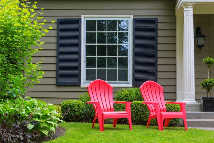 deux chaises Adirondack rouges devant la maison grise