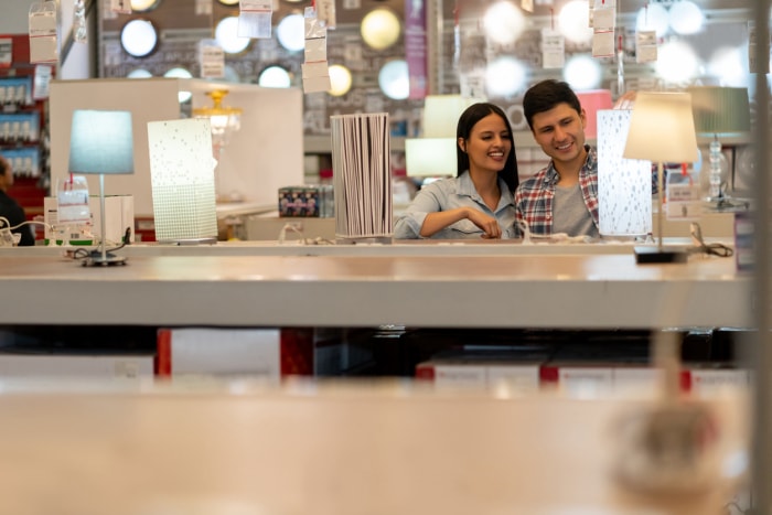 Couple heureux achetant une lampe dans un magasin de bricolage