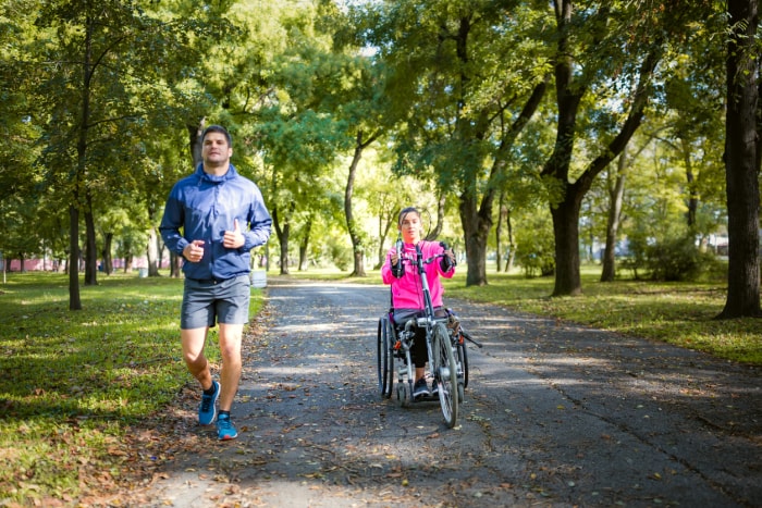 iStock-1286515623 communauté planifiée Femme en fauteuil roulant pratiquant une activité sportive en plein air avec son petit ami