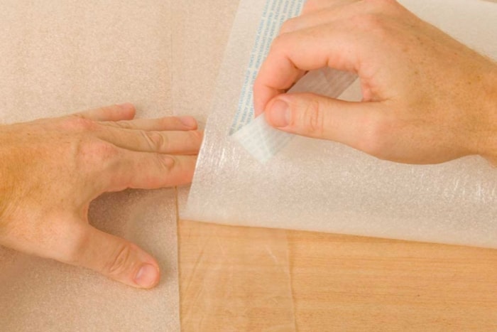 Décollement des bandes adhésives de la sous-couche de plancher sur un plancher en bois