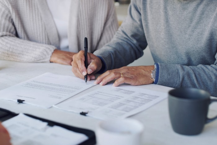 Deux personnes signant des documents contractuels.