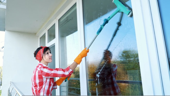 Femme nettoyant une fenêtre