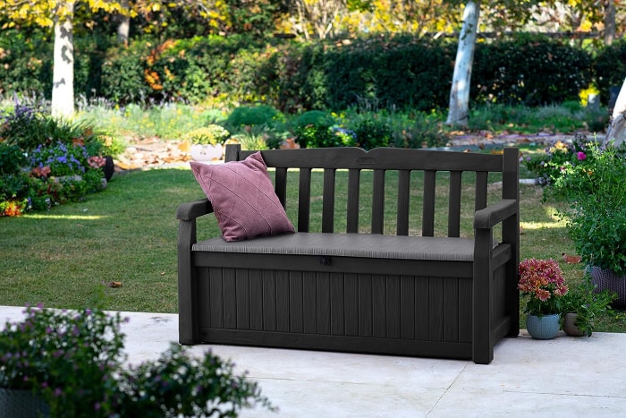 Banc de jardin en bois foncé avec compartiment de rangement.