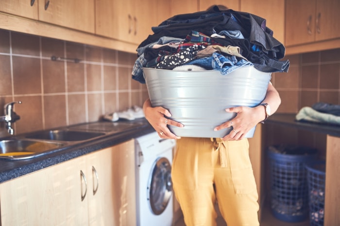 iStock-1135785938 Personne interdite pour les corvées du Nouvel An tenant une pile de linge.jpg