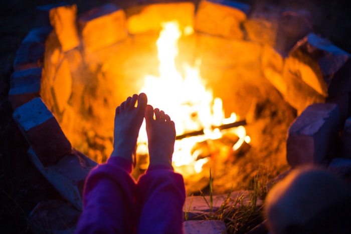 vue des pieds d'un enfant devant un feu de joie