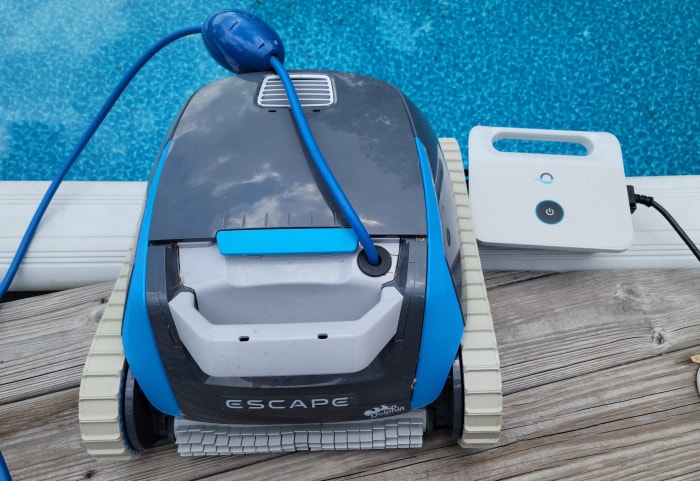 L'adaptateur secteur du robot nettoyeur de piscine Dolphin Escape installé à côté d'une piscine hors sol