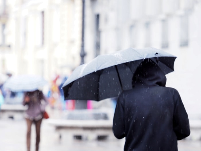 farmers almanac winter forecast - vue de dos d'une personne tenant un parapluie sous la pluie