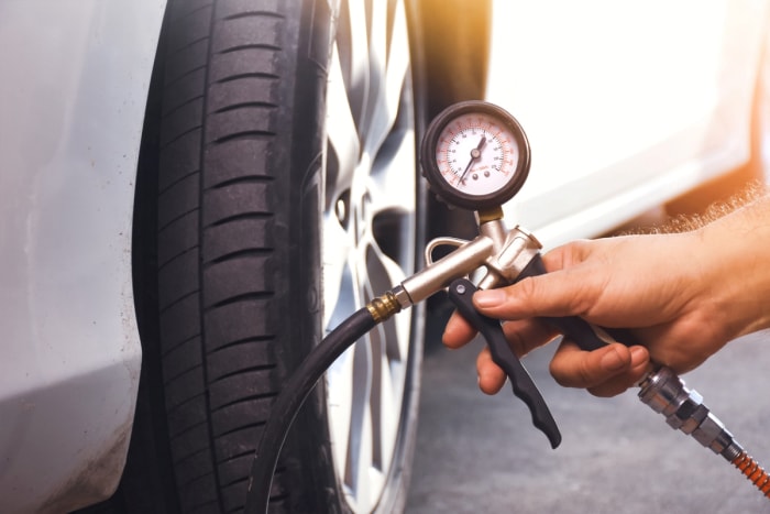 tâches d'entretien de voiture - pression des pneus à la main