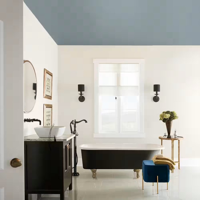 Salle de bain moderne avec plafond aux tons bleus et gris.