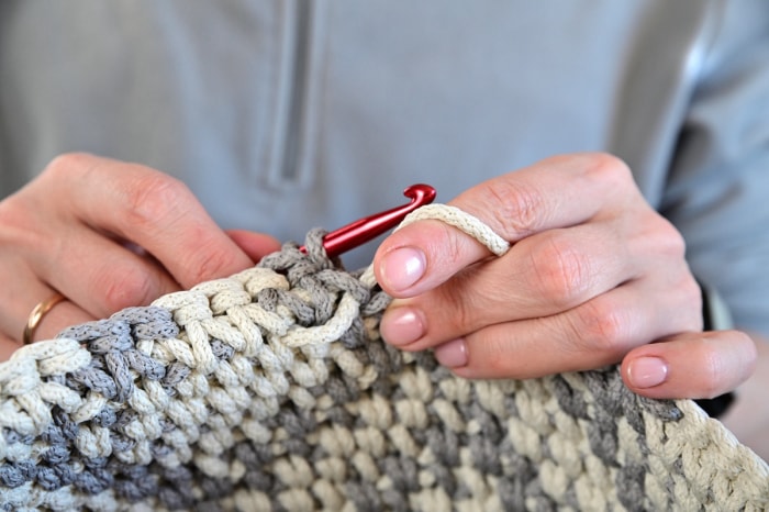 Une personne crochetant un petit panier pour décorer sa maison.