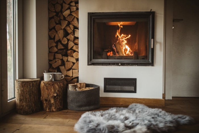 Un feu douillet à côté de piles de bois.