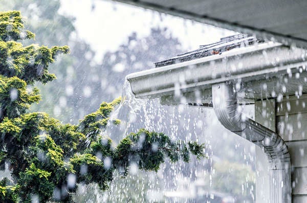 Gros plan des gouttières de la maison vues à travers la pluie