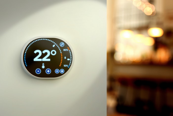 Thermostat intelligent fixé au mur dans la maison.