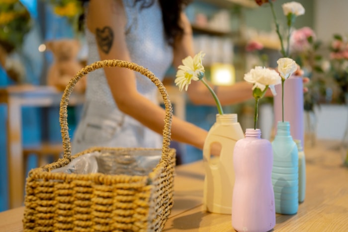 Bouteilles en plastique réutilisées comme vases contenant des œillets simples