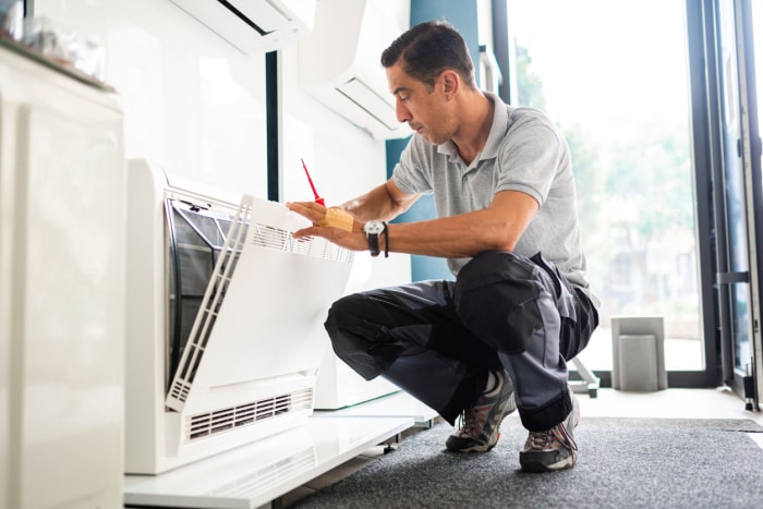 technicien travaillant sur un climatiseur