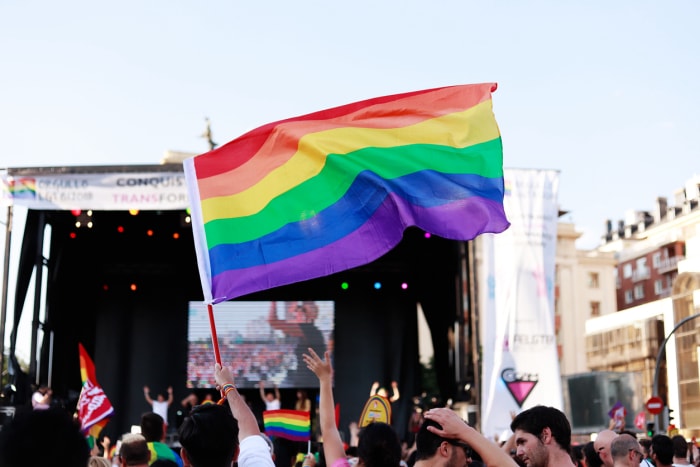 Drapeau arc-en-ciel flottant devant un concert le jour de la Gay Pride