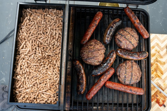 Une trémie pleine à côté de la viande grillée sur le meilleur gril à pellets de moins de $500