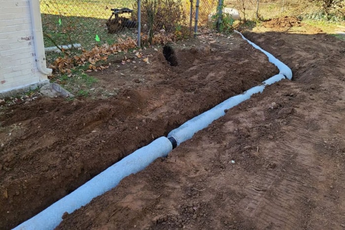 Un drain français en cours d'installation dans une cour.