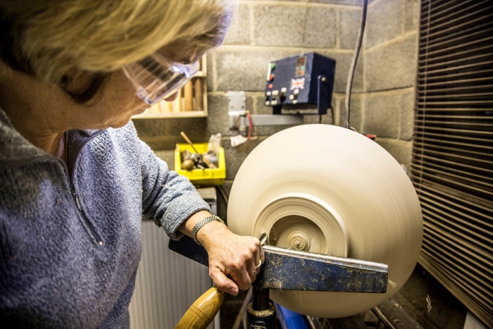 femme tournant un grand bol sur un tour - tournage sur bois pour débutants - nouvelle année, nouvelle compétence