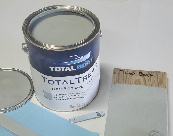 Un pot ouvert de peinture pour pont Total Boat sur une table blanche