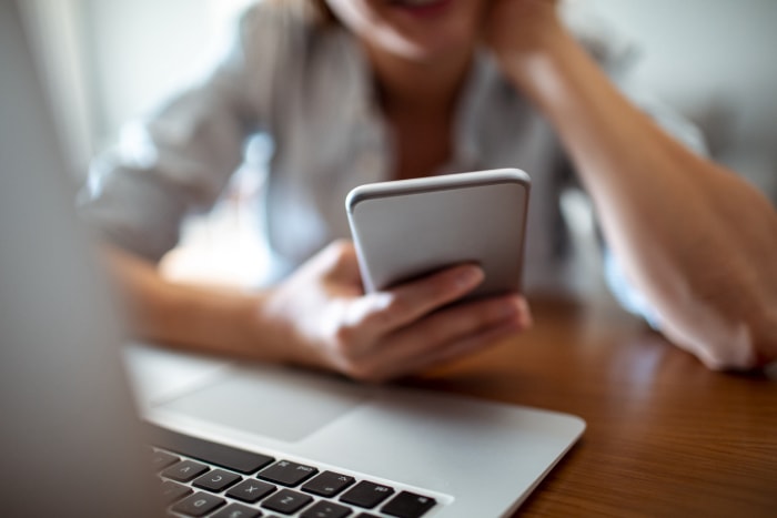 iStock-1187536032 femme avec sonnette vidéo vérifiant son iPhone