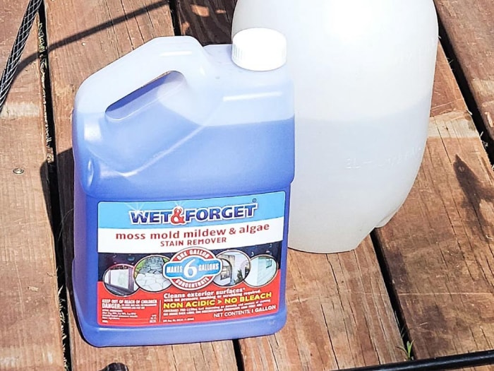 Bouteille de nettoyant pour terrasse Wet & Forget posée sur une terrasse en bois