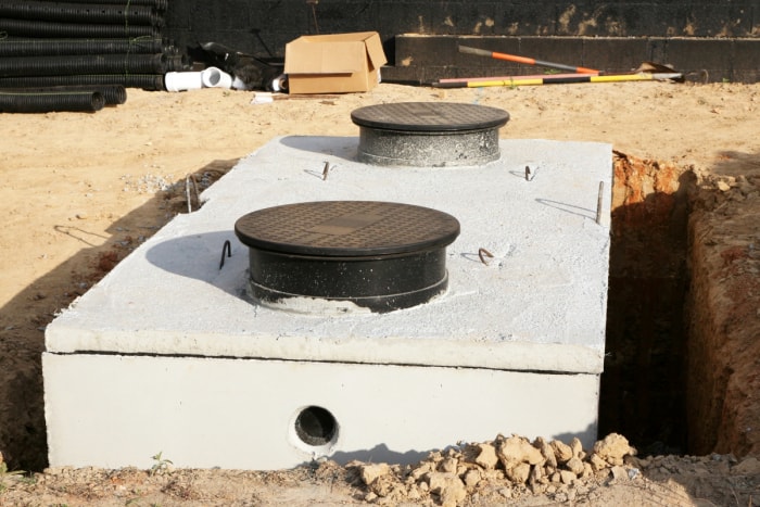 Une nouvelle fosse septique en béton a récemment été installée dans le sol.