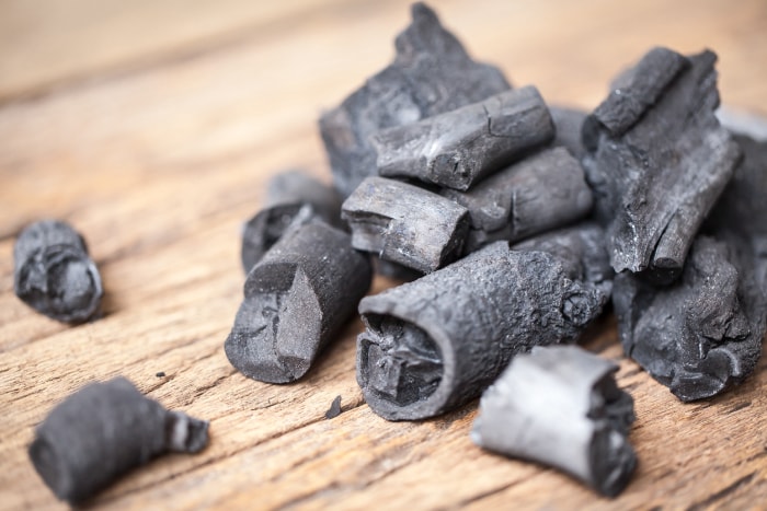 tas de morceaux de charbon de bois sur une surface en bois