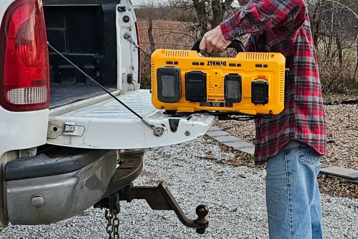 La station de charge Dewalt avec plusieurs batteries d'outils électriques branchées pour la charge pendant le chargement dans la benne d'un camion.