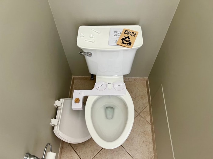 Tushy Bidet placé sur un WC blanc sur le point d'être installé