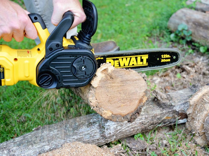 Quelqu'un utilise la tronçonneuse DeWalt 20V pour couper l'extrémité d'une bûche