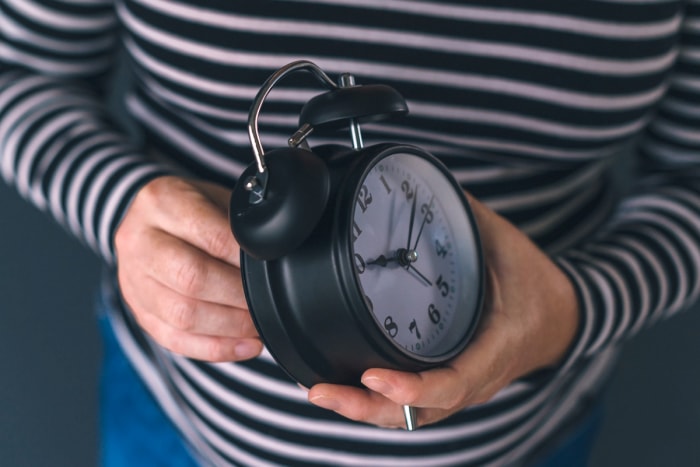 heure d'été 2023 - femme remontant une horloge