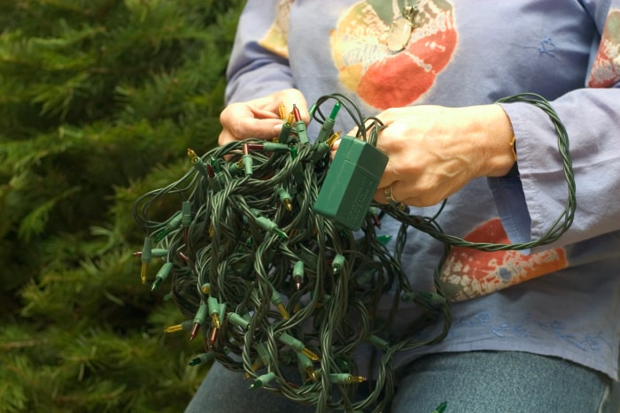 gros plan d'une femme testant des lumières de Noël