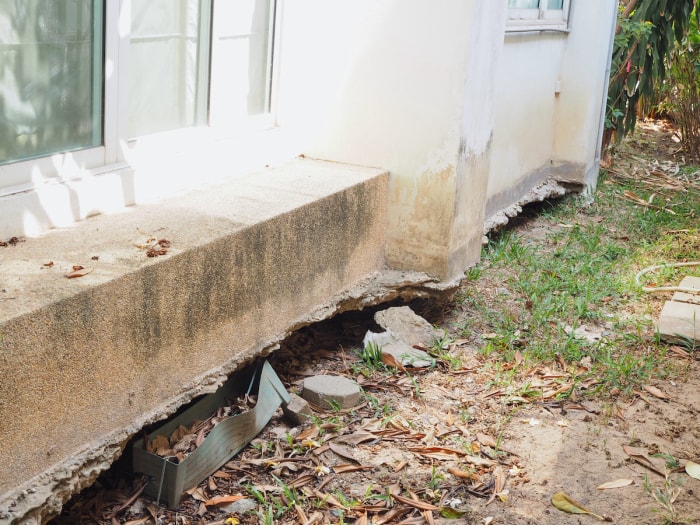 Une maison dont les fondations sont endommagées en raison d'une subsidence ou d'un affaissement du terrain sous les fondations.