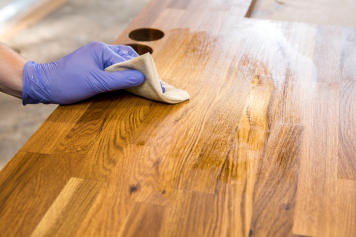 Personne essuyant une table en bois