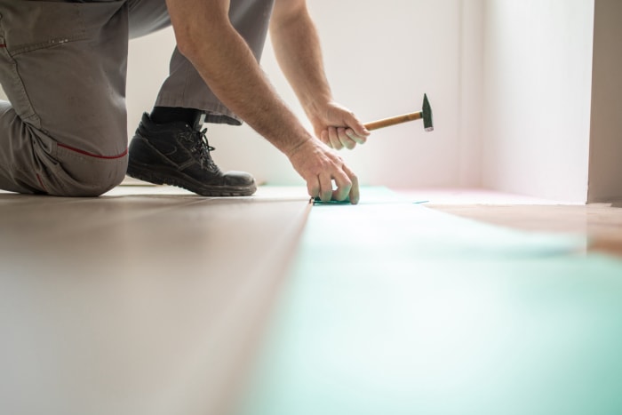 Homme installant un nouveau parquet stratifié