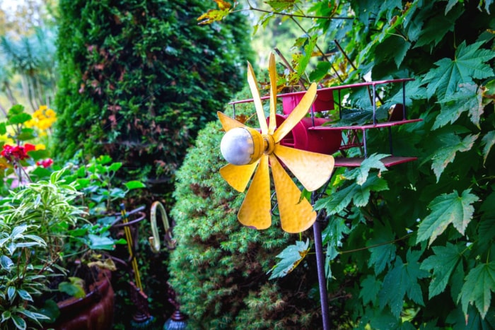 Un-plan-whirligig-pinwheel-is-in-a-lush-garden (Un plan-whirligig-pinwheel est dans un jardin luxuriant).